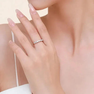 Woman wearing a sterling silver eternity band with round gemstones on her finger