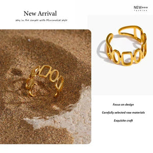 18K gold-plated open ring with geometric design displayed on sandy surface