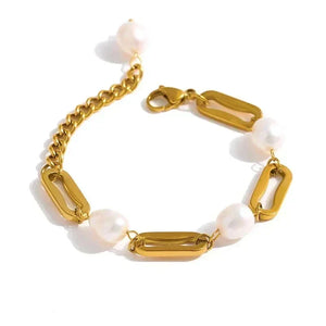Gold chain bracelet with white beads on a white background
