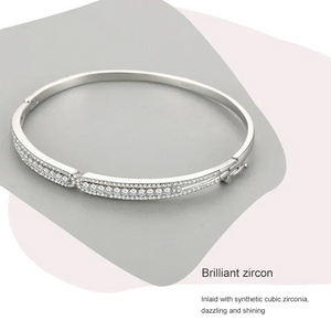 Silver bracelet with zircon stones on a gray background