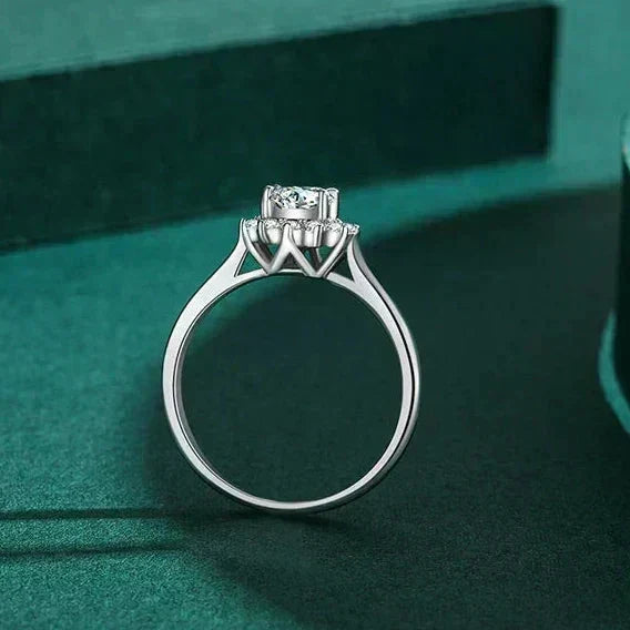 Silver ring with a diamond on a green textured surface