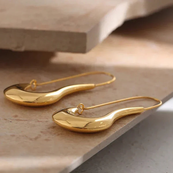Gold earrings on a stone surface with 'Design Details' text.