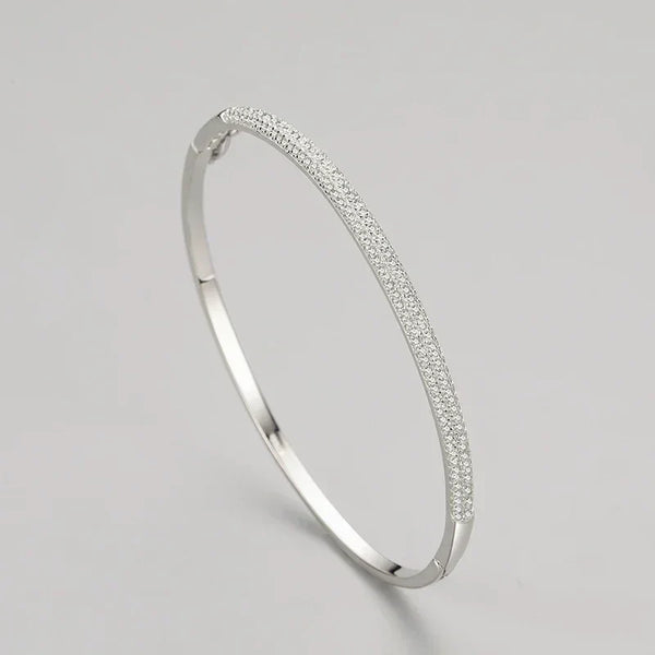 Elegant 925 silver bangle with pavé cubic zirconia on a plain light background