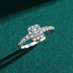 Silver ring with a diamond on a green textured background