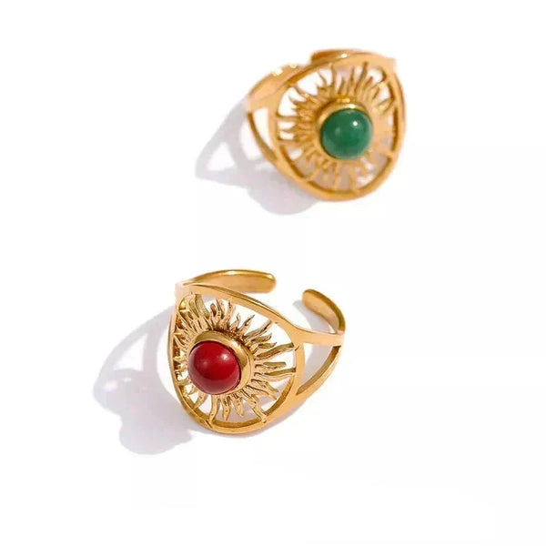 Two gold rings with gemstones on a white background