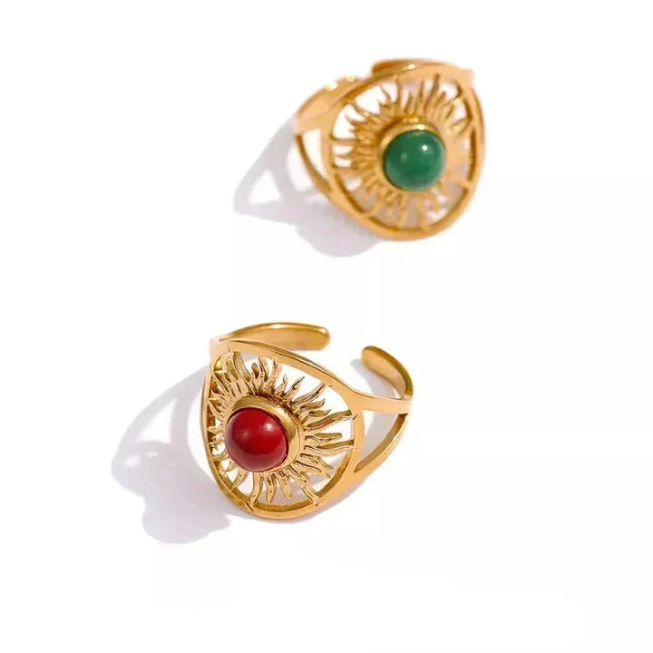 Two gold rings with gemstones on a white background