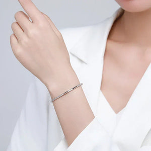 Minimalist 925 silver bangle bracelet on woman's wrist, elegant jewelry fashion style