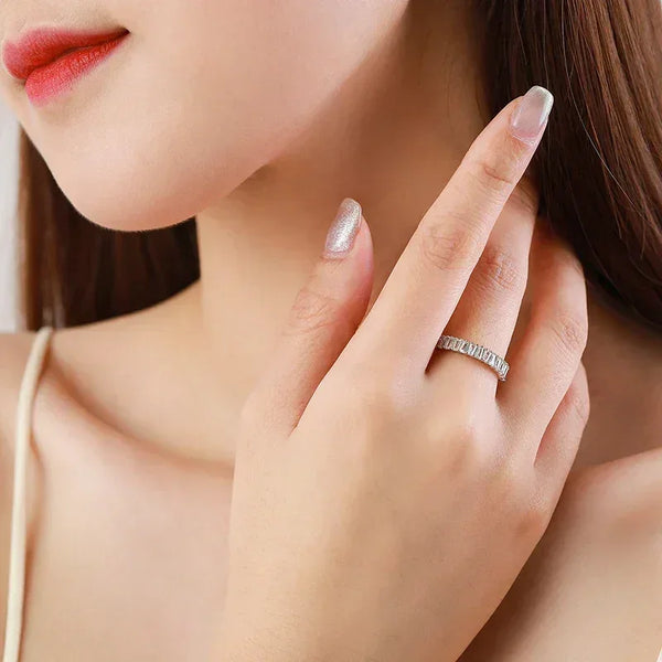 Woman wearing a silver baguette-cut ring on her finger, close-up hand and face