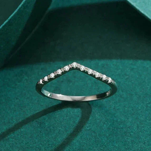 Silver ring with small diamonds on a green textured surface