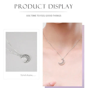 Silver necklace with a moon design worn by a person, displayed against a light background.