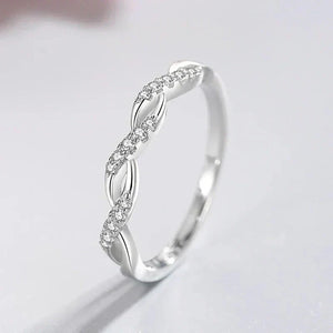 Sterling silver twisted ring with sparkling crystal accents on a light background