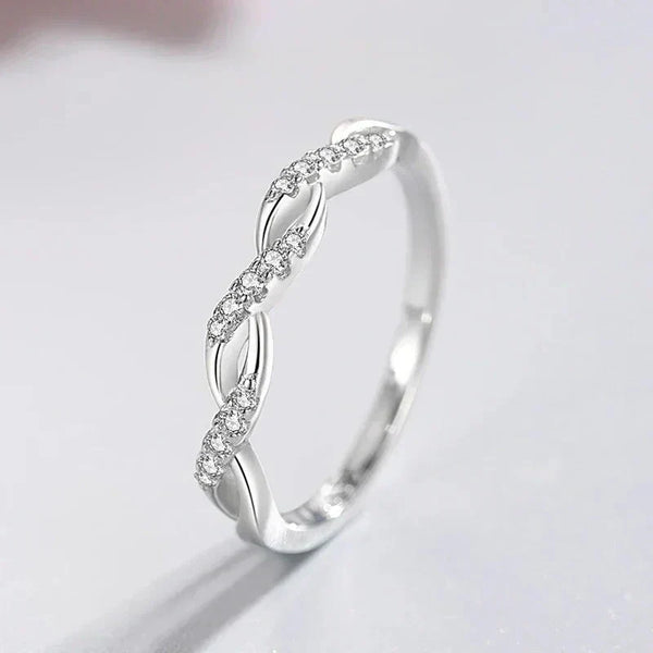 Sterling silver twisted ring with sparkling crystal accents on a light background
