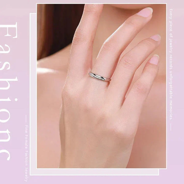 Silver ring on a hand with a soft pink background