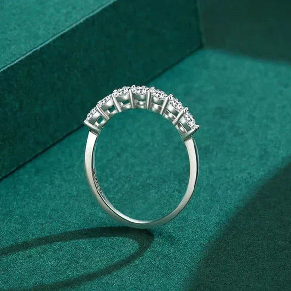 Silver ring with diamonds on a green textured surface