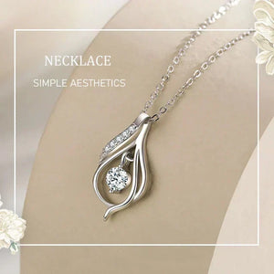 Silver necklace with a decorative pendant on a neutral background