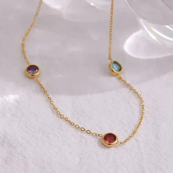 18K gold-plated chain necklace with colorful gemstone bezels on a light background