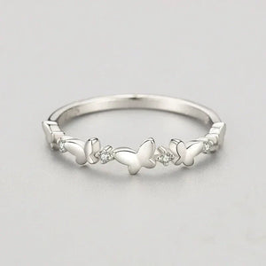 Silver butterfly ring with small diamonds on a light gray background