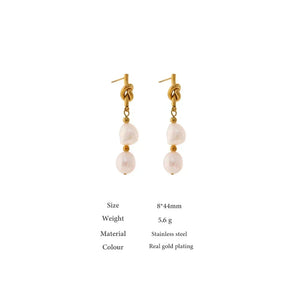 Gold earrings with pearl drops on a white background