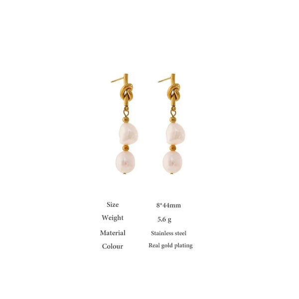 Gold earrings with pearl drops on a white background