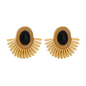 Pair of gold earrings with black centers on a white background