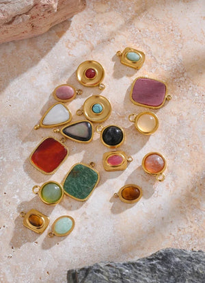 Gold jewelry with colorful gemstones on a textured stone surface, labeled 'Fashion Accessories'.