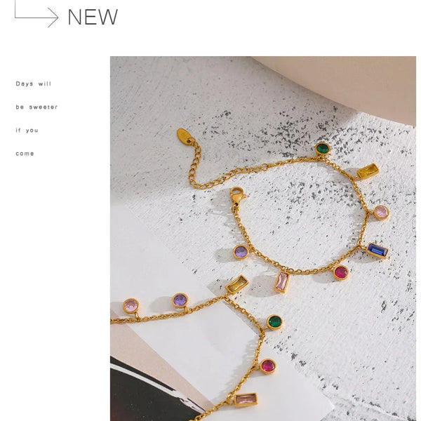 Gold bracelet with colorful gemstones on a textured surface