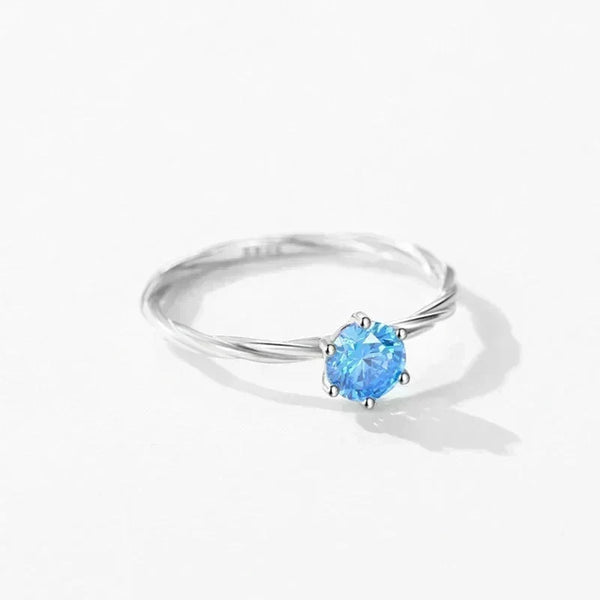 Silver ring with a blue gemstone on a white background