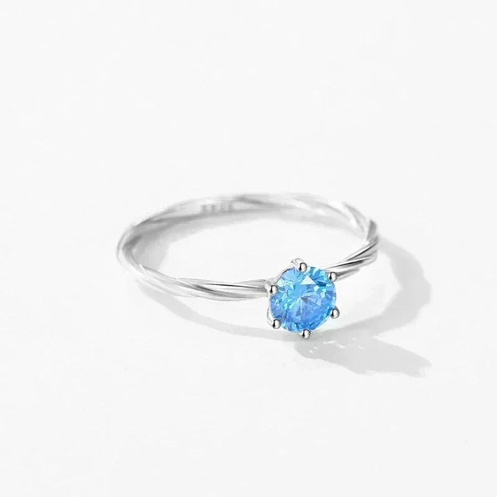 Silver ring with a blue gemstone on a white background