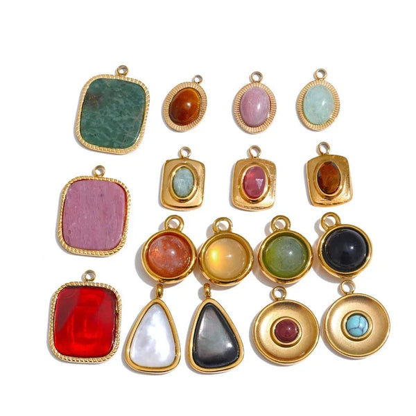 Collection of colorful gemstone pendants with gold settings on a white background