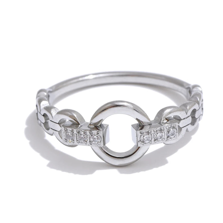 Silver ring with interlocking design and embedded diamonds on a white background