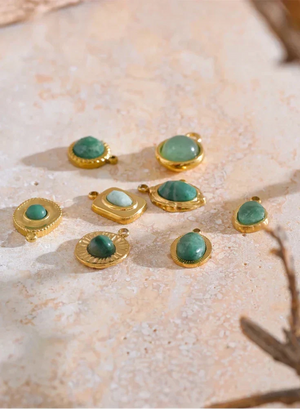 Gold-framed turquoise stones on a textured beige surface