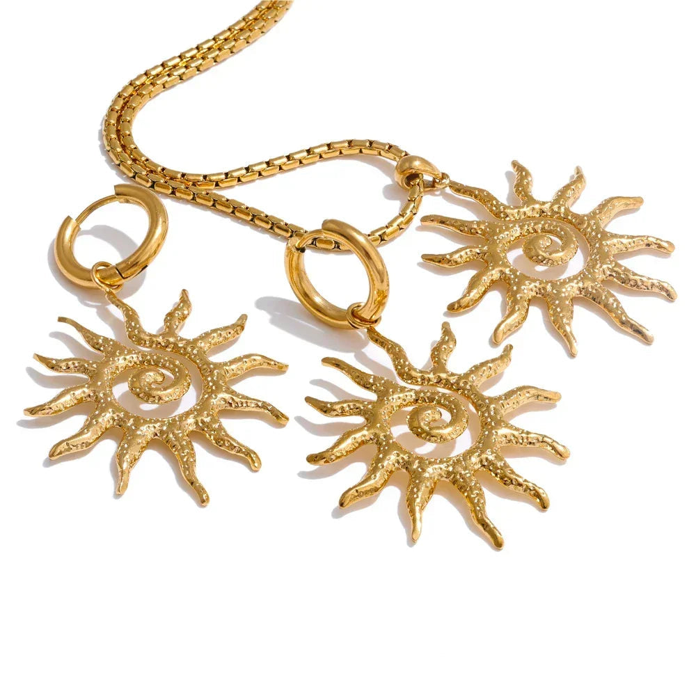 Gold sun-shaped earrings on a white background.