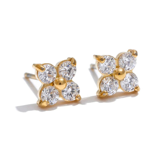 Gold earrings with clear gemstones on a white background