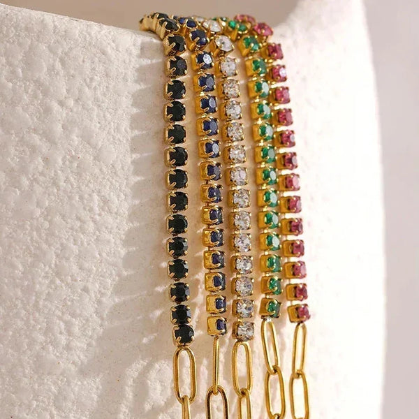 Gold-plated chain bracelets with multicolored gemstone accents displayed on white stand