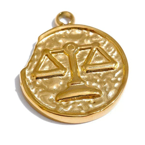 Gold pendant with a scale design on a white background