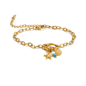 A gold chain anklet featuring a lobster clasp, an adjustable extender chain, and three charms: a starfish, a seashell, and a small turquoise bead.