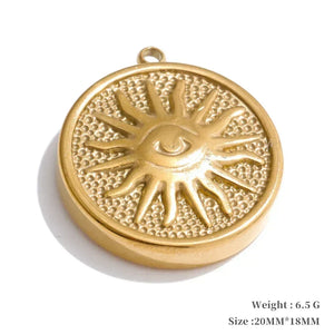 Gold pendant with sun design and eye in center on white background