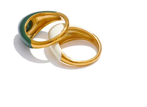 Three gold rings with green, white, and gold bands on a white background