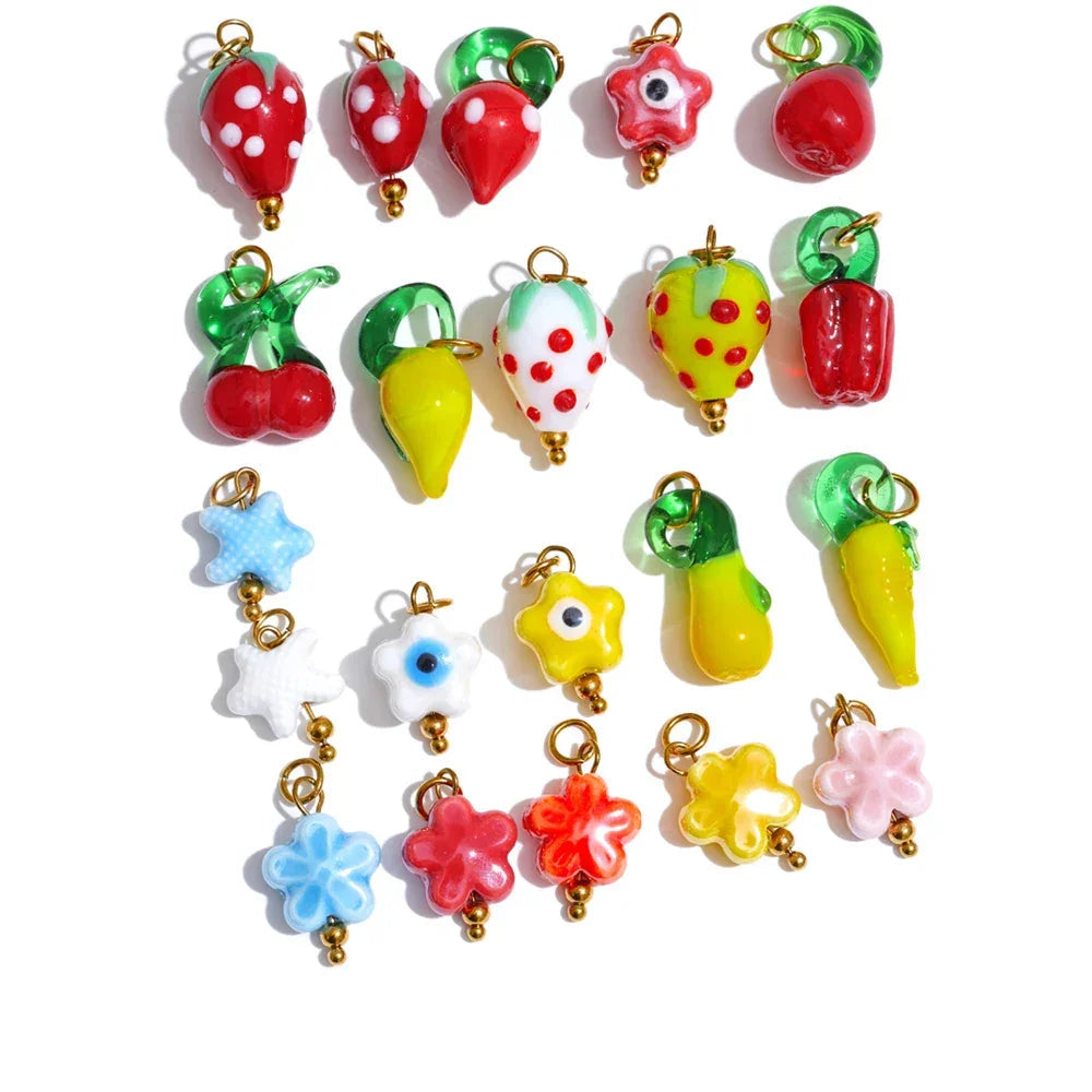 Colorful resin charms including fruits, vegetables, and flowers on a white background.