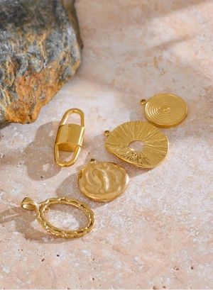 Gold jewelry pieces on a textured stone surface
