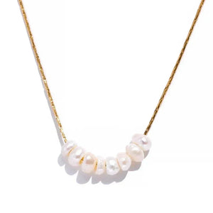 Gold-plated chain necklace with seven white freshwater pearls on white background