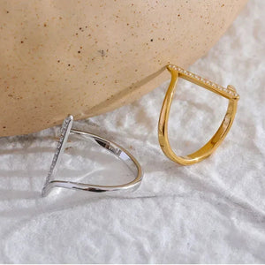 Silver and gold-plated geometric rings with pavé accents on textured white fabric