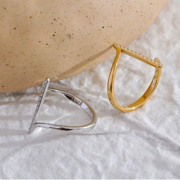 Silver and gold-plated geometric rings with pavé accents on textured white fabric