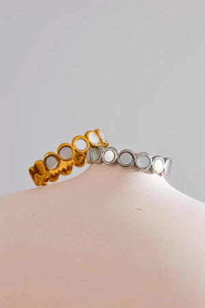 Two rings, one gold and one silver, on a mannequin bust against a gray background.