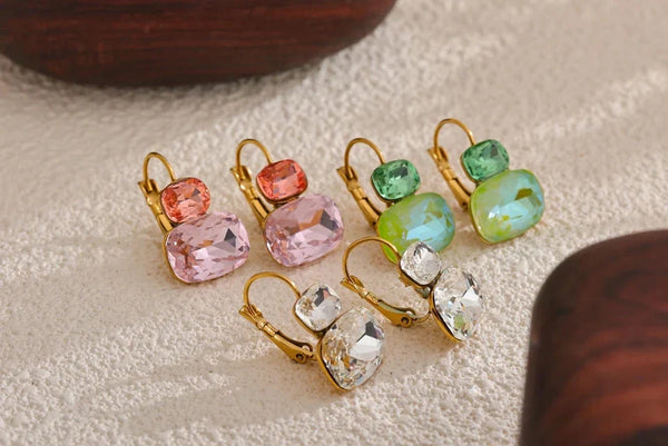 Colorful gemstone earrings on a neutral background .