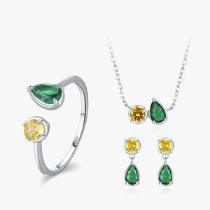 Jewelry set with rings, necklace, and earrings featuring green and yellow gemstones on a white background.