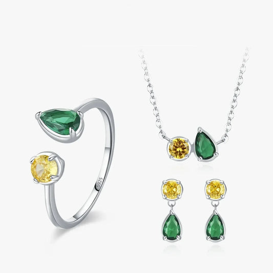 Jewelry set with rings, necklace, and earrings featuring green and yellow gemstones on a white background.