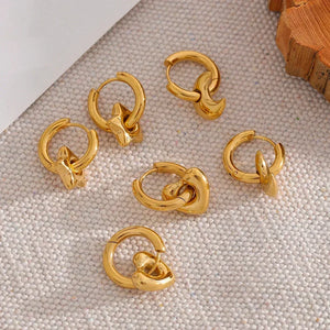 Astral Affection Hoops - TM & CO. JEWELS - Gold hoop earrings on a textured surface.
