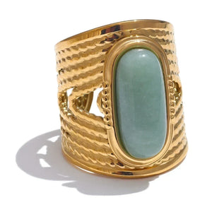 Gold ring with a green stone on a white background