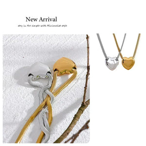 Two necklaces, one gold and one silver, on a textured white surface with 'New Arrival' text.